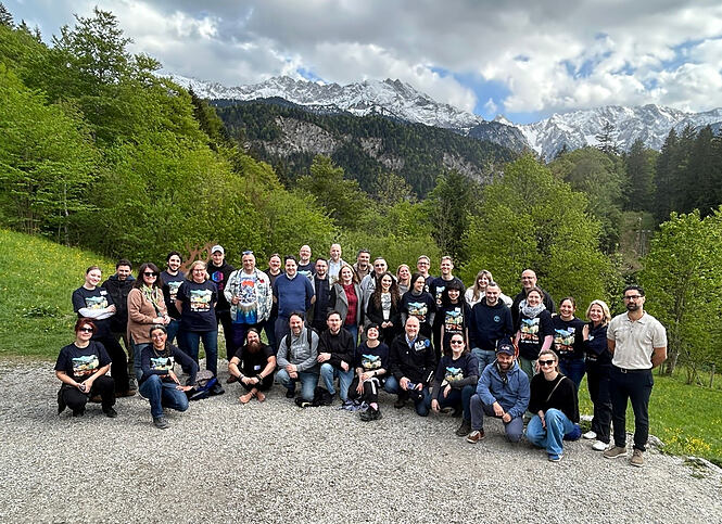 Huch!-Team und die internationalen Vertriebspartner vor Bergkulisse